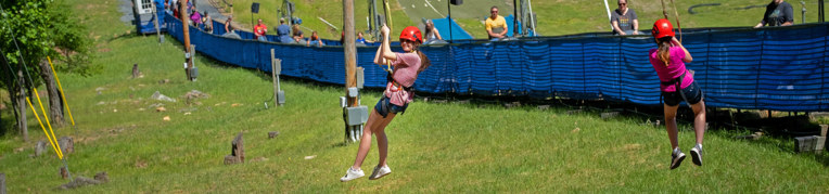Two girls zip lining at  Family Adventure Park