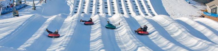 Four riders go down the snow tubing hill at  Resort